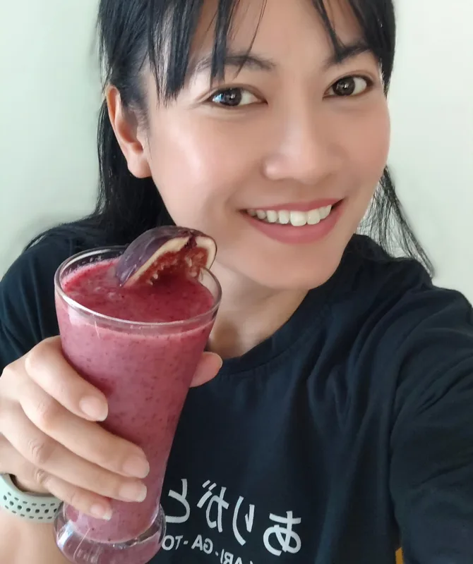 A glass of pink fig smoothie topped with a fig slice